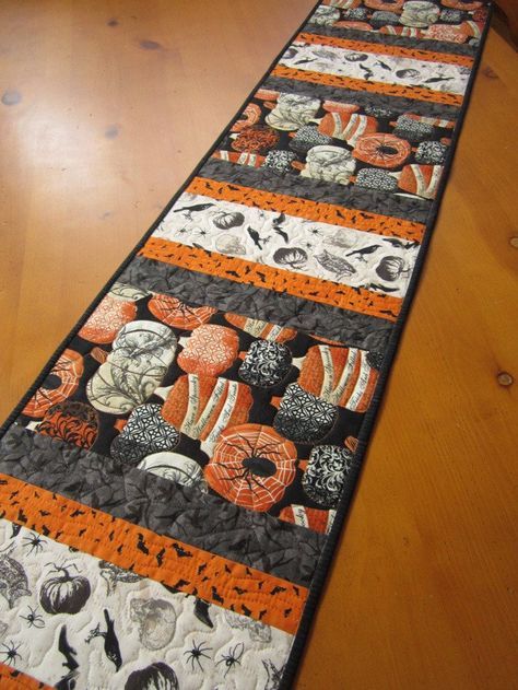 an orange and black table runner on a wooden floor