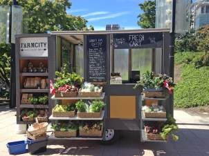 a food truck with lots of vegetables on display