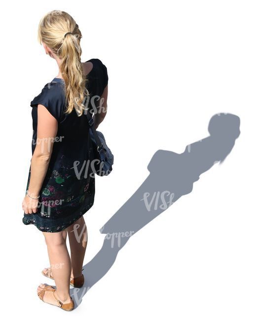 a woman standing in front of a white background with her shadow on the wall behind her