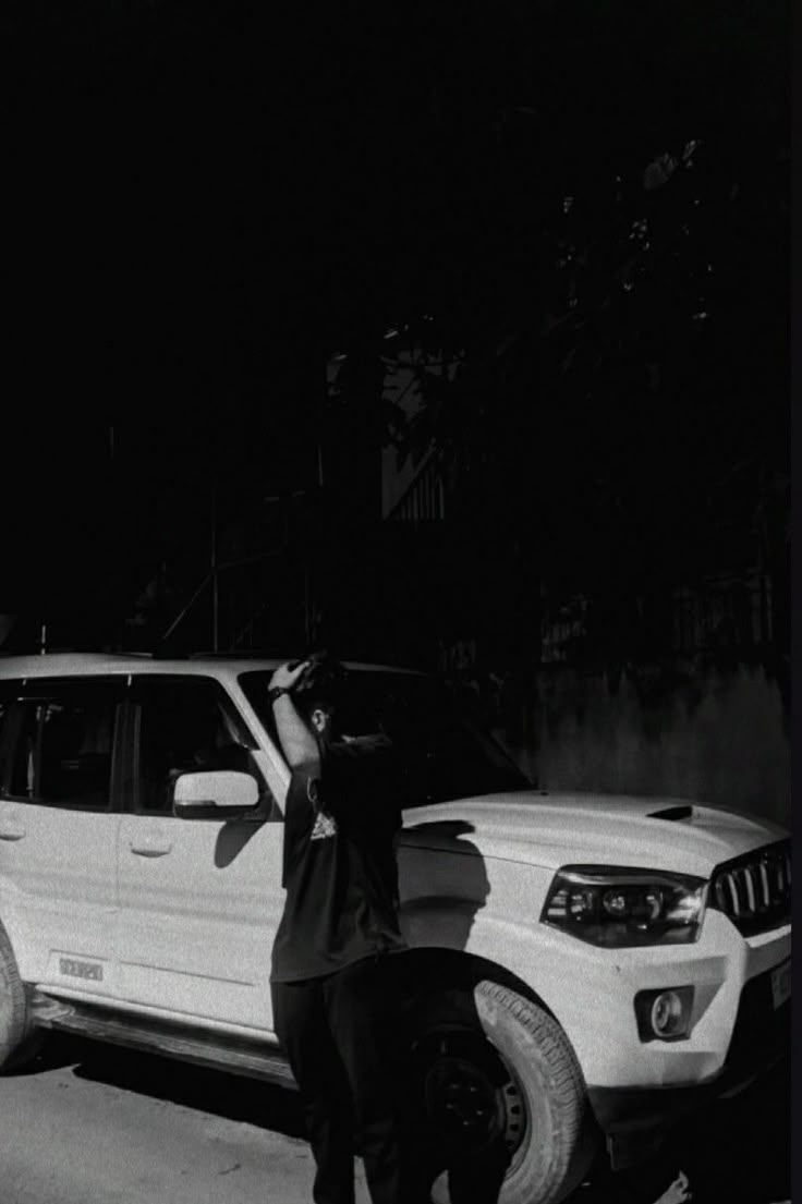 a man standing next to a white suv