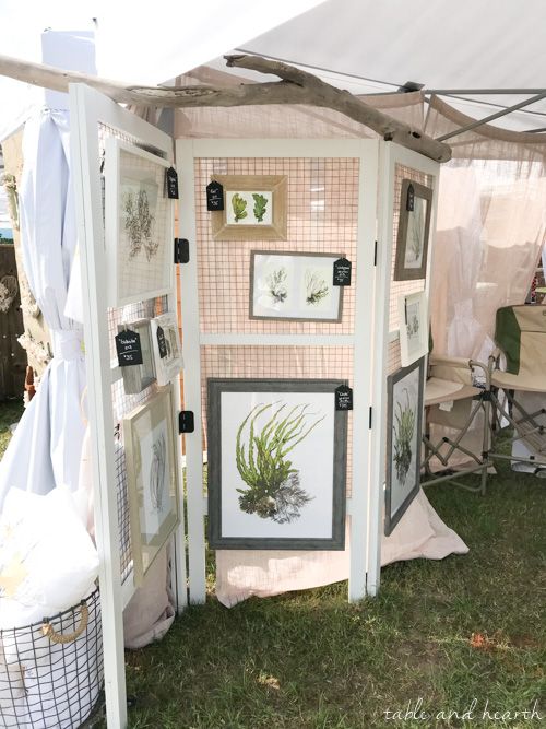 an outdoor booth with pictures and plants on it