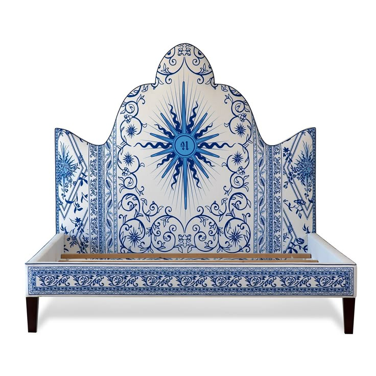 a decorative blue and white bed with an intricate headboard