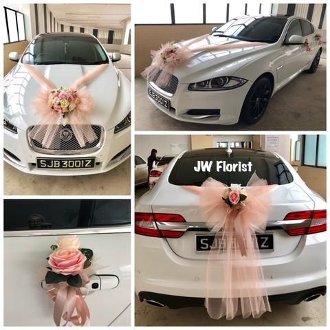 wedding car decorated with pink flowers and ribbons