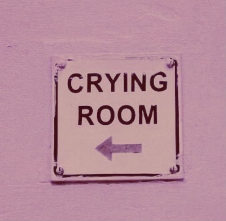 a sign that says crying room with an arrow pointing to the right on a purple wall