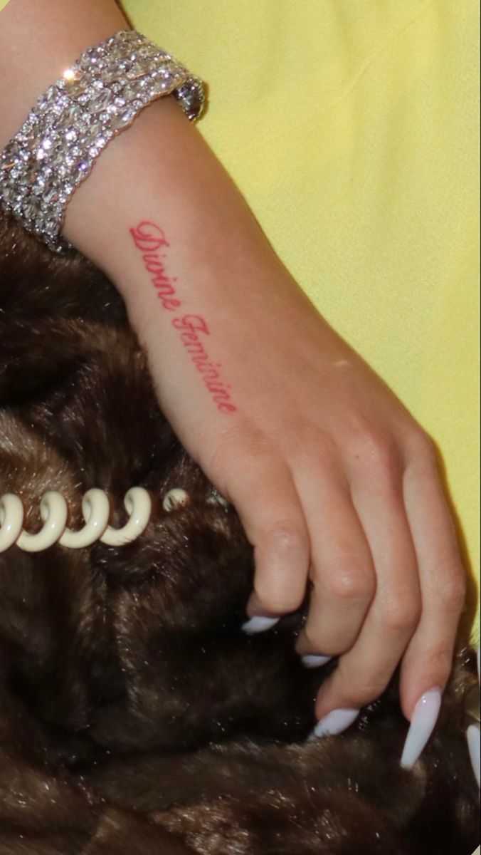 a close up of a person's arm with a tattoo on her left wrist