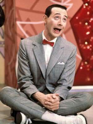 a man in a suit and bow tie sitting on the floor