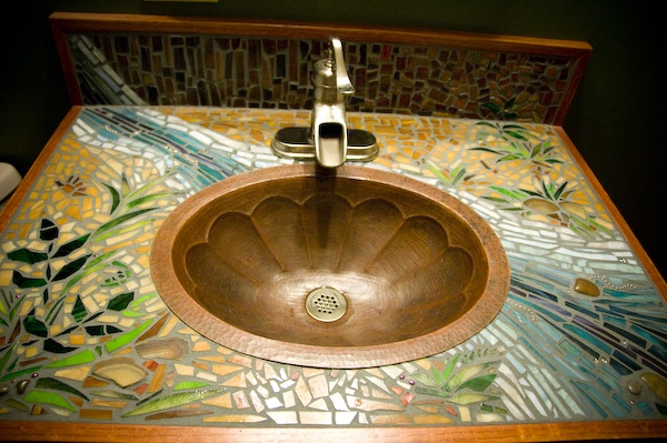 a wooden sink sitting on top of a counter next to a wall mounted faucet