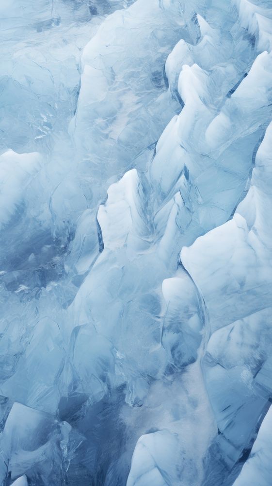 an airplane is flying over the ice covered mountains and valleys that look like they are floating in the water