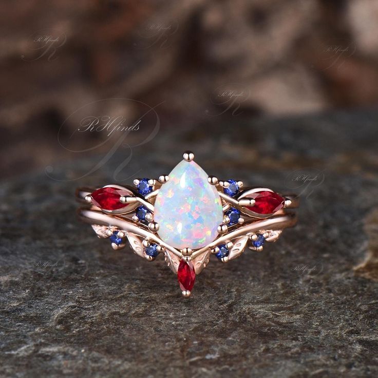 a white opal and red garnetia ring on top of a stone surface