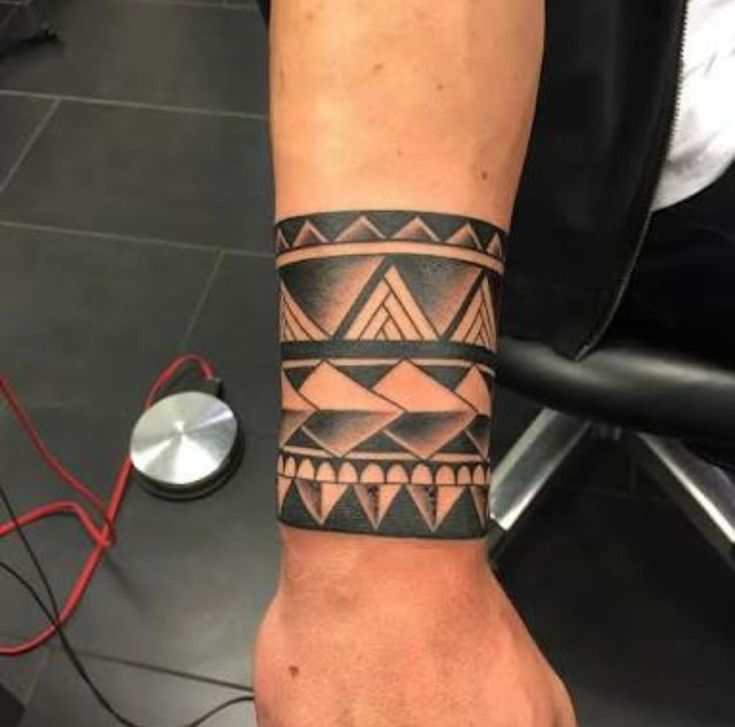 a man's arm with a tattoo on it that has an abstract design in black and grey