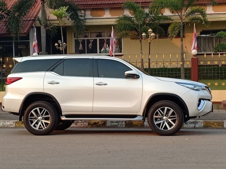 a white suv parked in front of a building