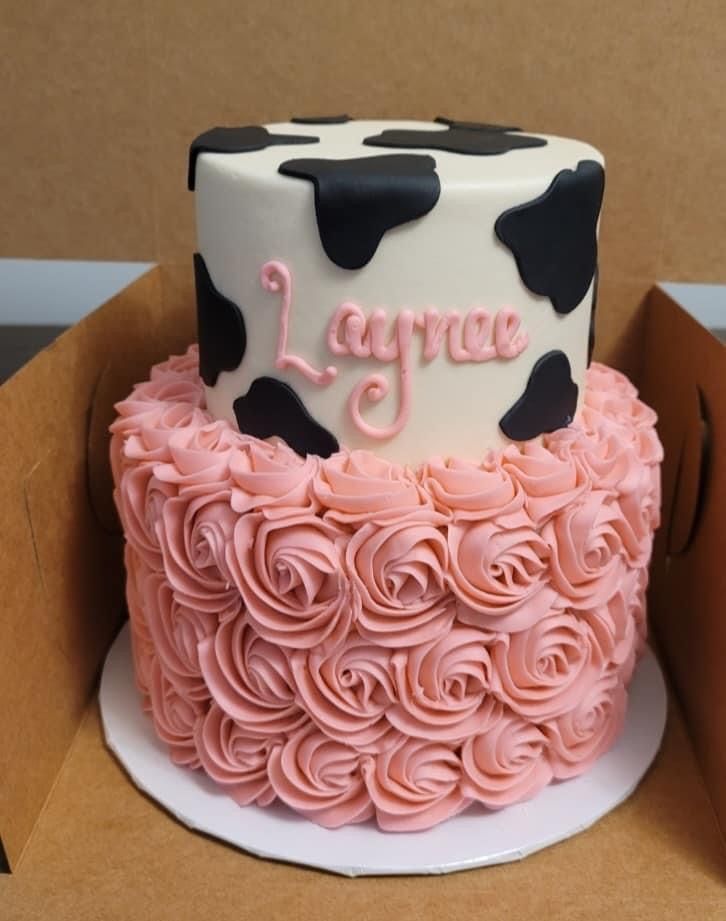 a pink and black cake sitting on top of a cardboard box