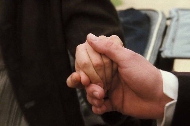 two people holding hands while standing next to each other