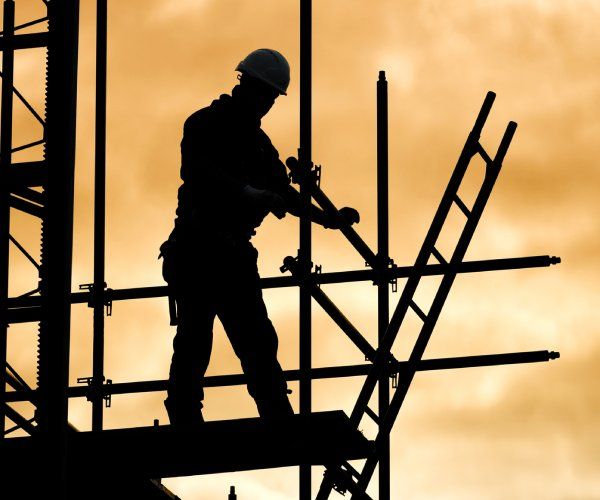 a man standing on top of a building next to scaffolding