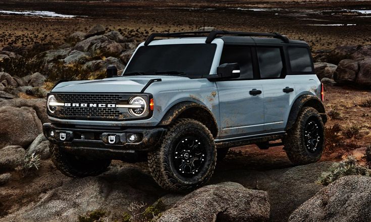 a blue truck is parked on some rocks