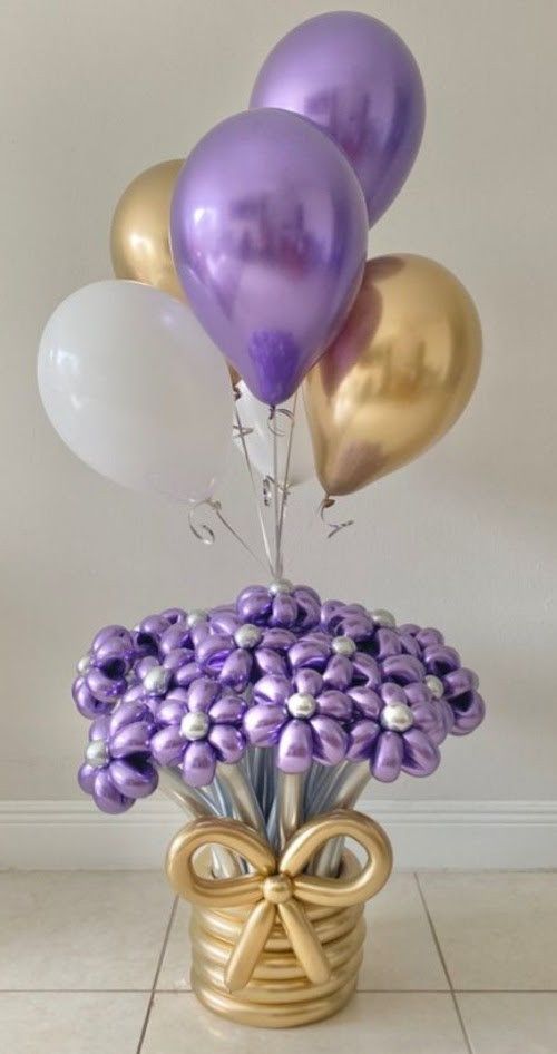 purple and gold balloons are in a vase