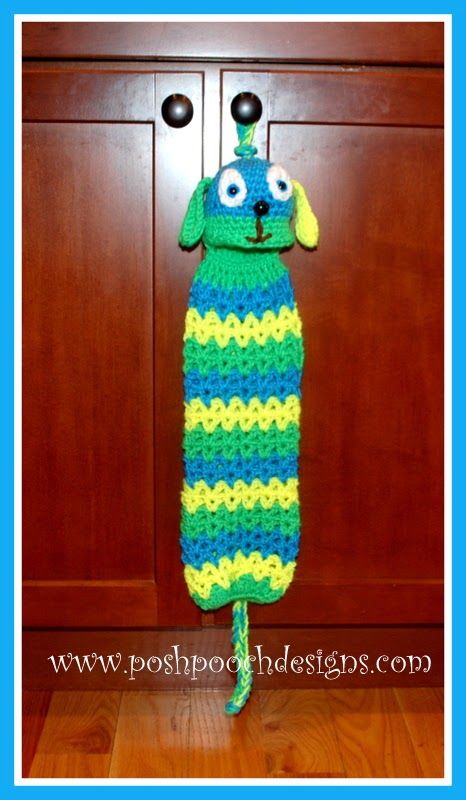 a crocheted dog wearing a blue and green striped dress with eyes on it's head