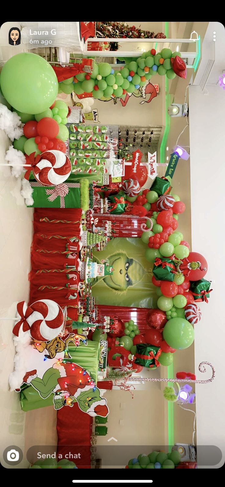 christmas decorations and balloons are displayed on the wall in front of a shelf with candy