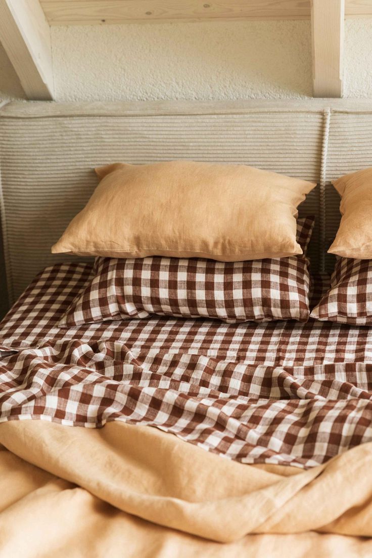 a bed with brown and white checkered comforter on it's headboard