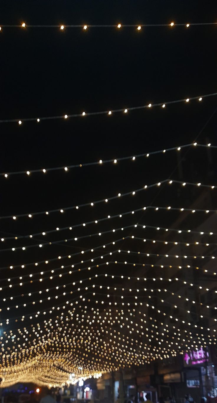 the lights are hanging from the ceiling above the street