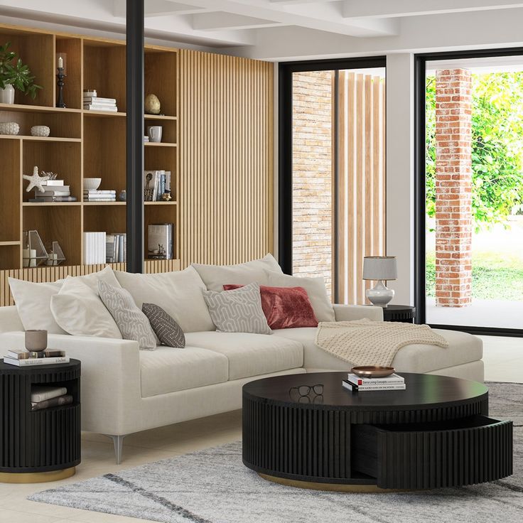 a living room filled with furniture and lots of windows next to a brick wall covered in bookshelves