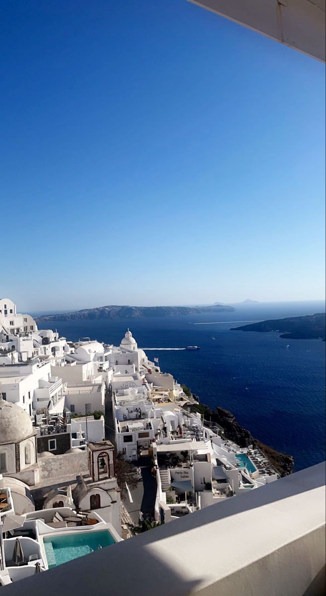 a view of the ocean and buildings from a rooftop top restaurant in mykonos, greece