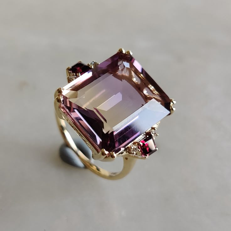 ITEM DESCRIPTION: --> The ring is made from Solid 14K Yellow Gold. Gemstone used is absolutely natural and ethically sourced.  --> Ametrine is naturally occurring gemstone which is a unique combination of Amethyst and Citrine.  --> Ametrine in Emerald Cut is studded with fine quality Rodo garnet and diamond  on its utmost precision. Gem: Ametrine Gem size: 17 x14 mm Gem shape : octogon Gem weight: 10.70 carat Gem : Rodo Garnet Gem size : 3 mm (2 pcs) Gem shape : Square  Gem weight : 0.38 CTS Gem : Diamond Gem size :1.5 mm Gem shape : Round Brilliant (4 pcs) Gem weight : 0.058 cts Gold purity: 14K (58.33% approx.) Gold weight: 3.72 grams  Total Gem weight : 11.14 cts Gross weight of ring: 5.95 grams >>The Gold purity is guaranteed and it comes with authentic 14K gold hallmark. >>Since these Luxury Gold Birthstone Ring With Diamond Accents, Luxury Classic Amethyst Ring With Gemstone Accents, Luxury Unique Gold Birthstone Ring, Square Gem Ring, Garnet And Amethyst Ring, Large Gemstone Rings, Ametrine Ring, Gem Rings, Rhodolite Garnet Ring