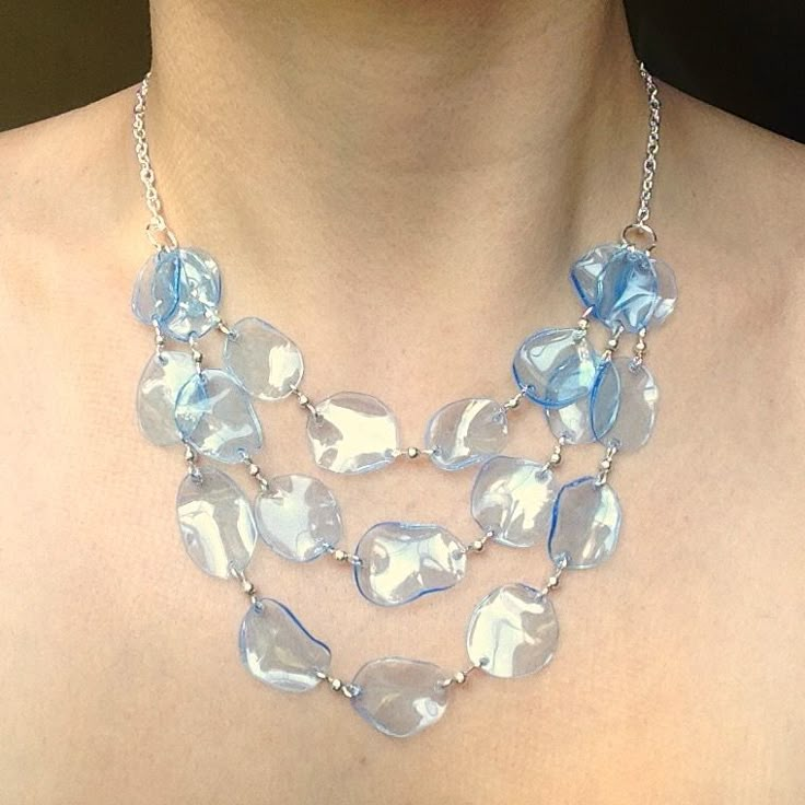 a woman wearing a blue necklace with clear glass hearts on it's sides and a silver chain around her neck