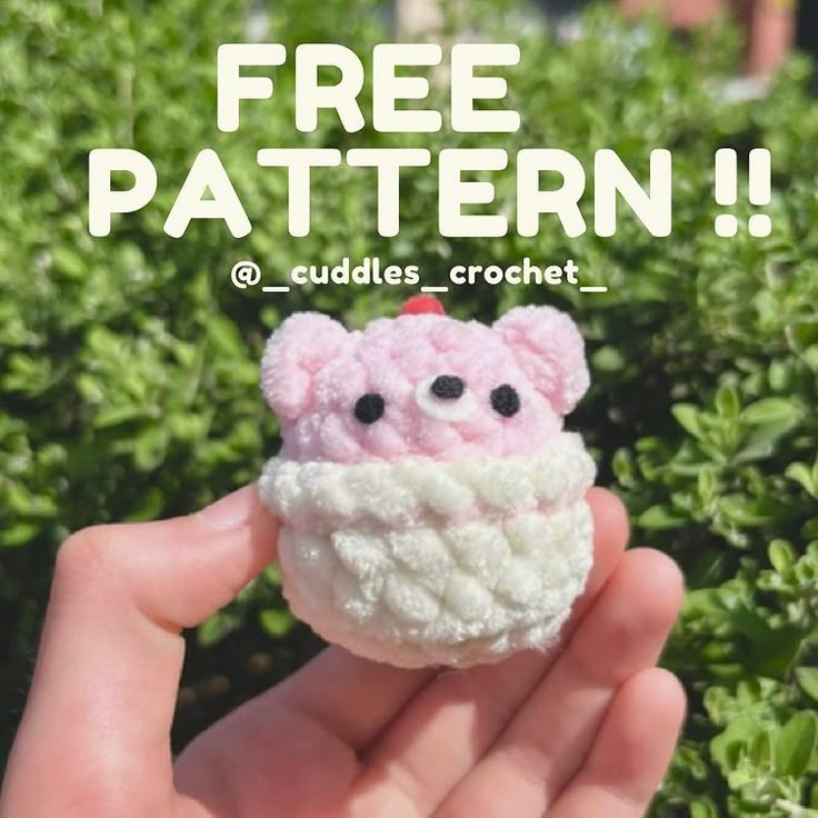 a hand holding a small crocheted pink and white object with the words free pattern on it