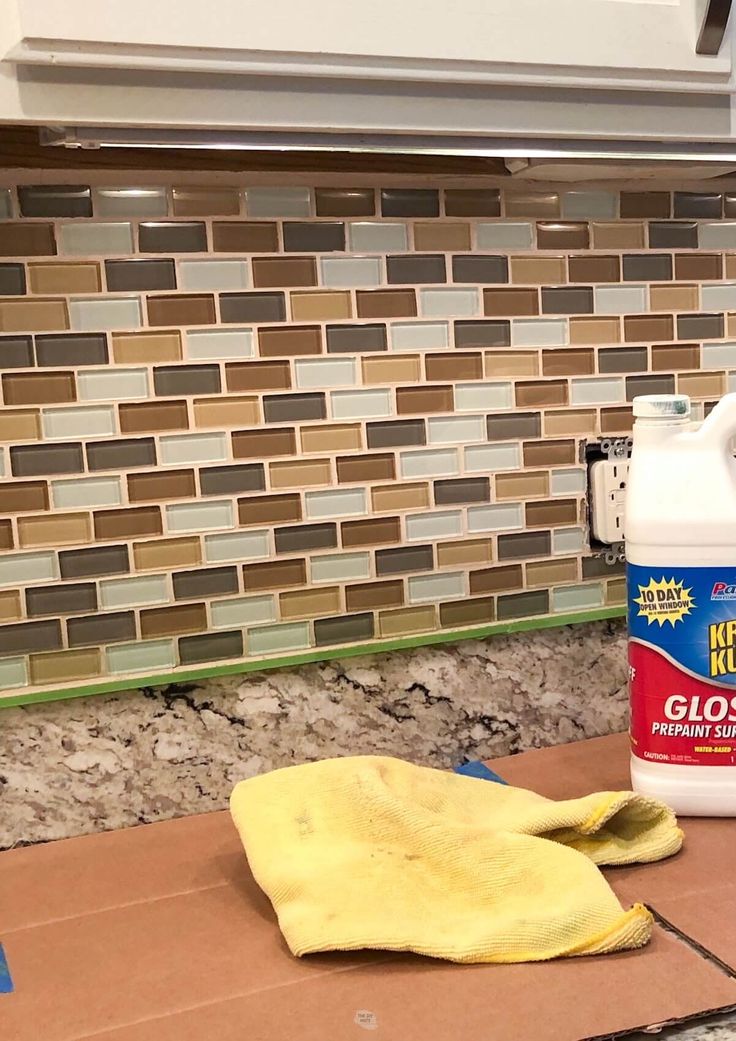 a yellow cloth is on the counter next to a bottle of cleaner