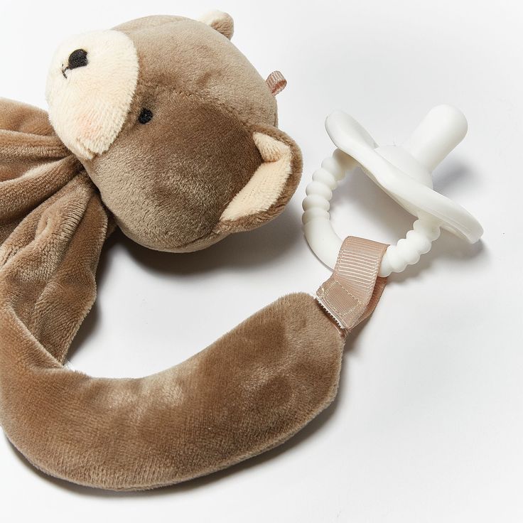 a brown stuffed animal with a pacifier attached to it's back and neck