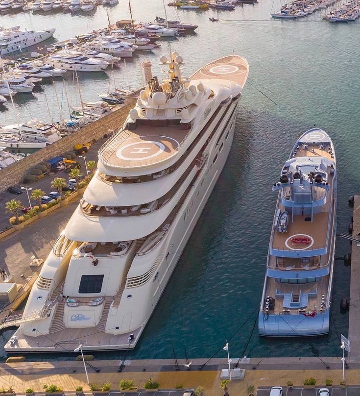 an aerial view of a large boat docked in the water with other boats around it