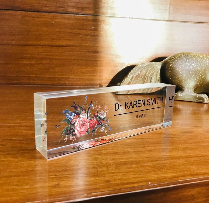 a wooden desk with a glass plaque on it that says dr karren smith