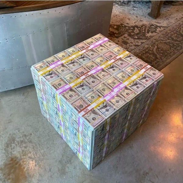 several stacks of money sitting on top of each other in front of a metal object