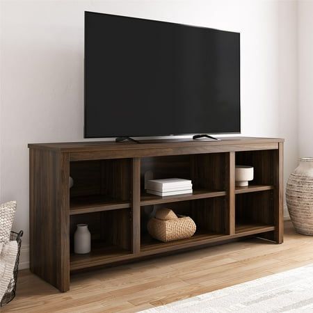 a flat screen tv sitting on top of a wooden entertainment center in a living room