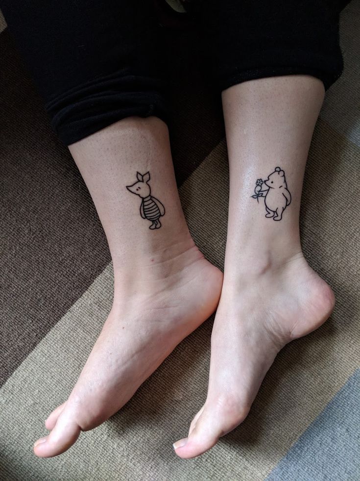 two people with matching tattoos on their feet, one has a dog and the other has a cat