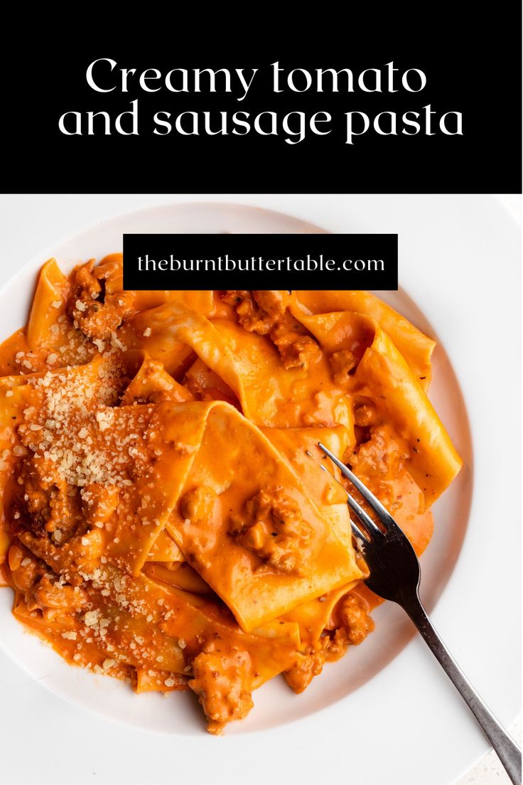 creamy tomato and sausage pasta on a white plate with a fork in front of it