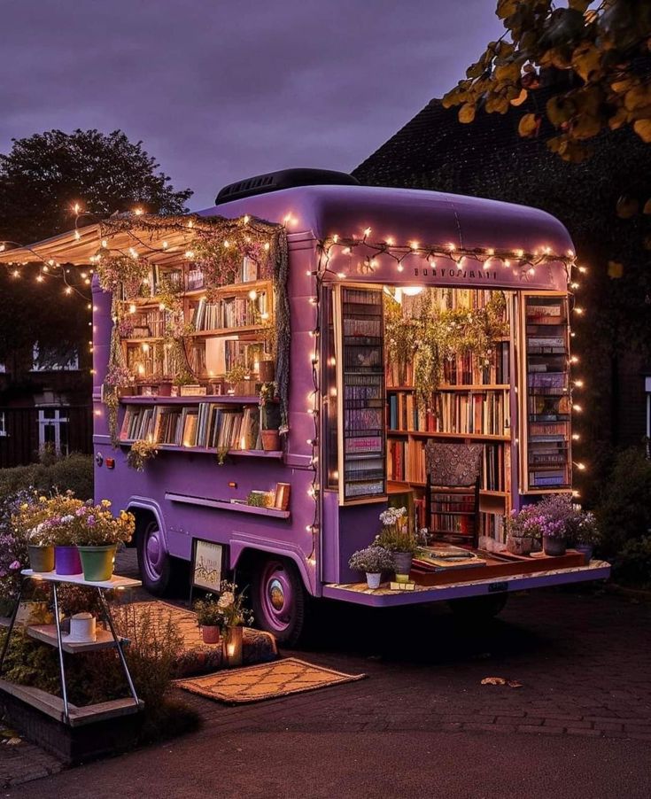 a purple food truck is decorated with lights and books