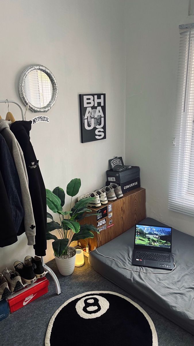 a laptop computer sitting on top of a bed next to a plant and other items