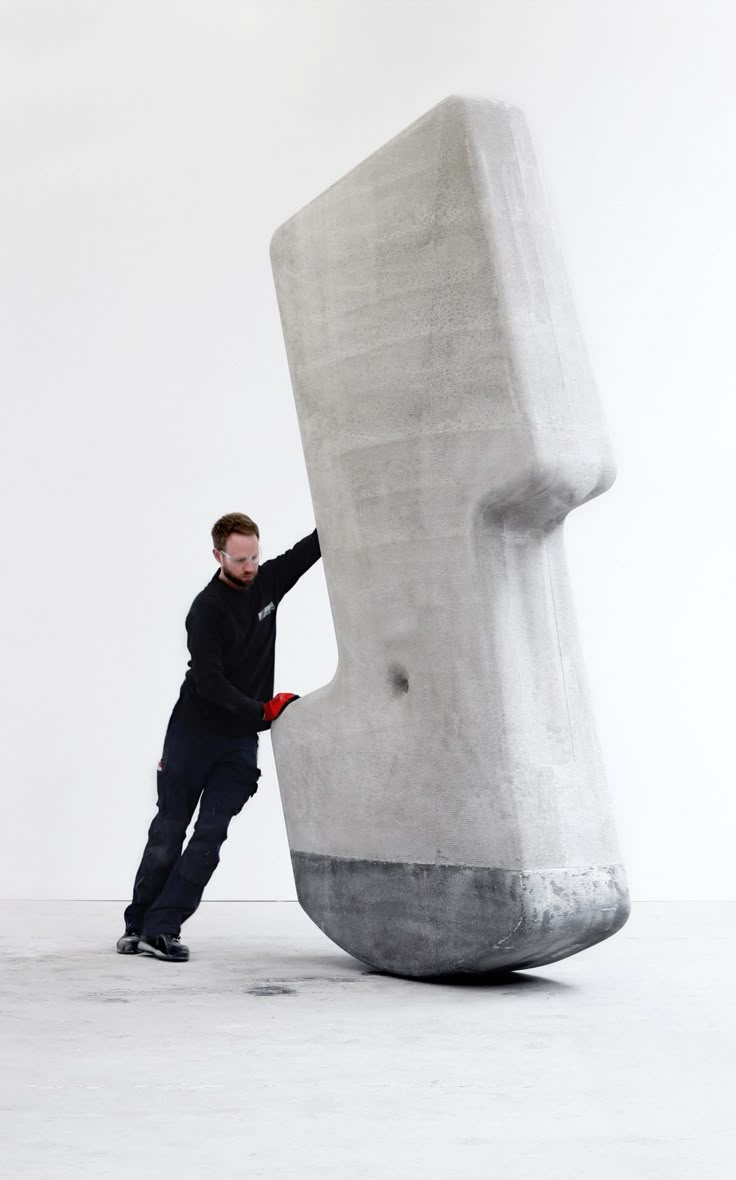 a man standing next to a giant sculpture