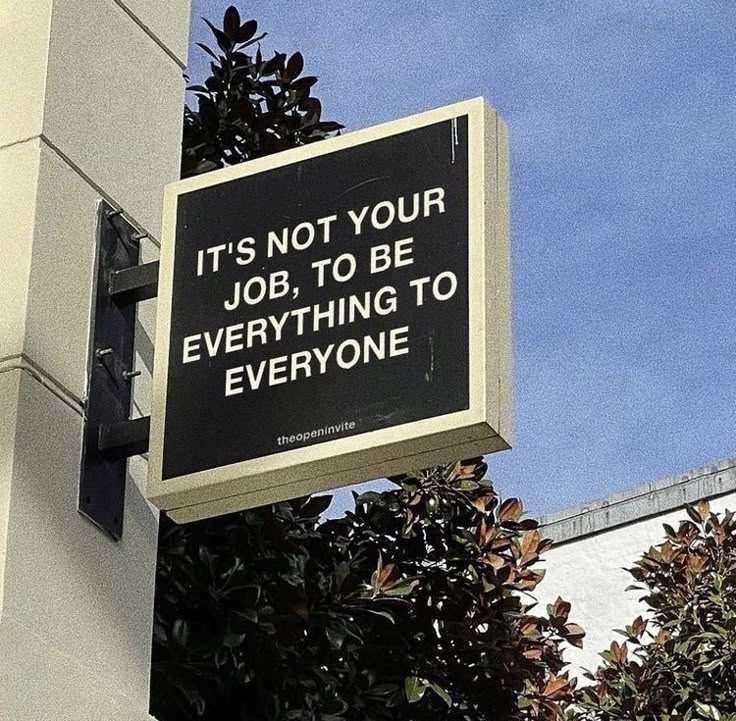 a sign hanging off the side of a building that says it's not your job to be everything to everyone