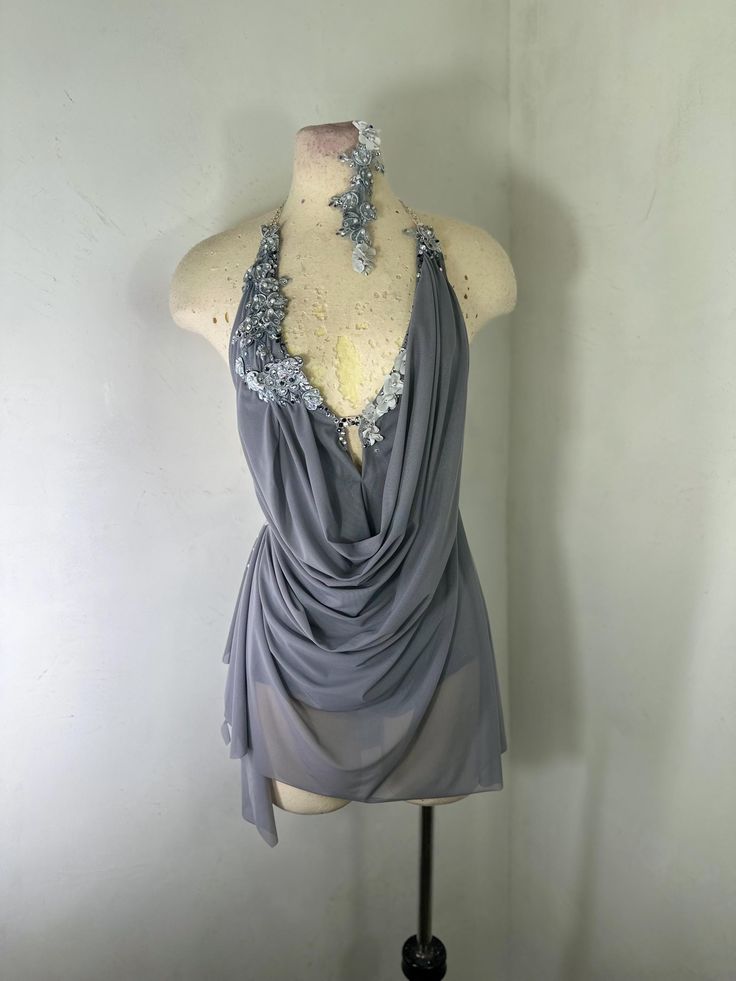 a mannequin wearing a gray top with silver sequins on the neck