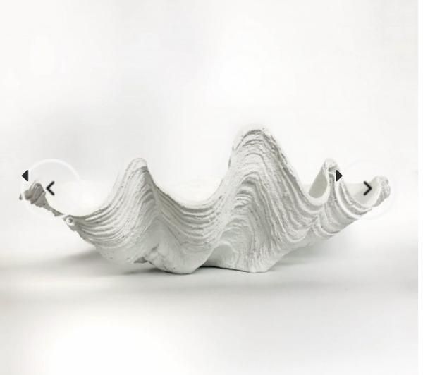 a white sculpture with two birds flying over it