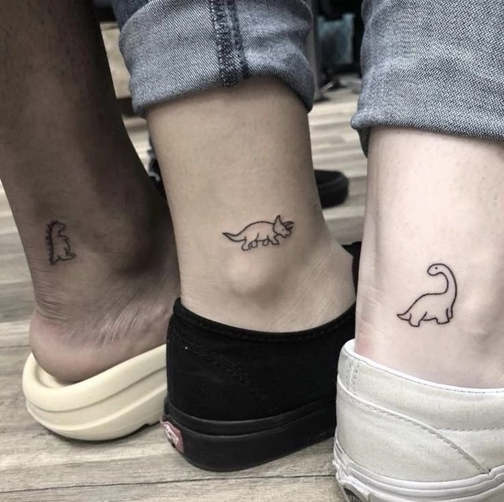 two people with matching tattoos on their feet, one has a dog and the other has a cat