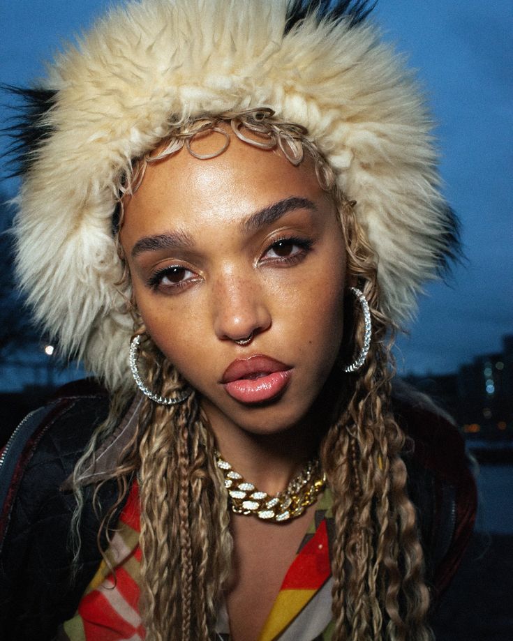 a woman with dreadlocks and a furry hat