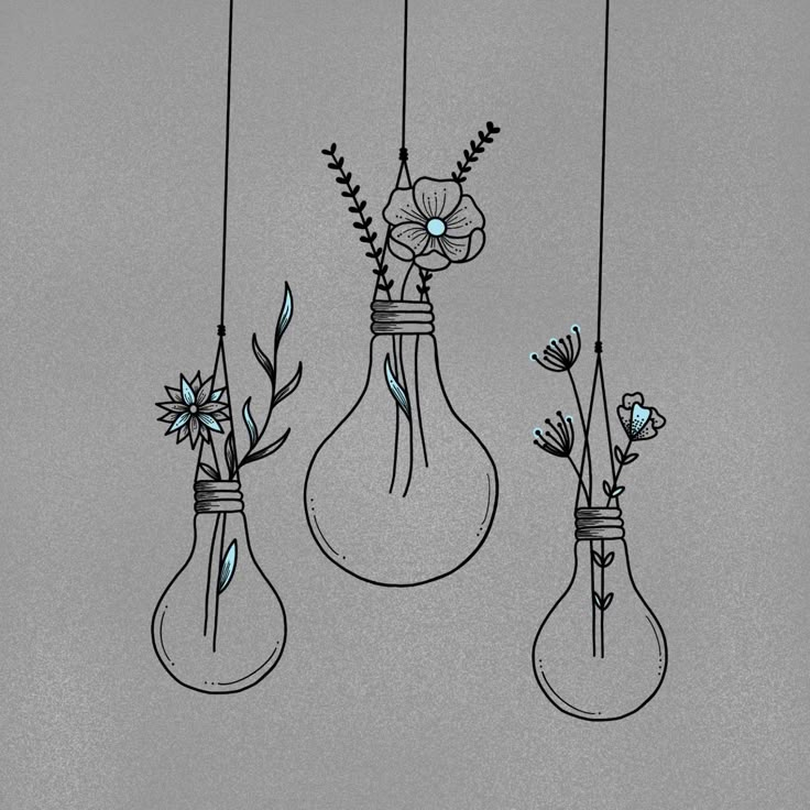 three light bulbs with flowers in them hanging from strings