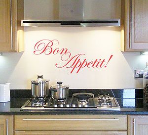 a stove top oven sitting under a sign that says bon appetit on it