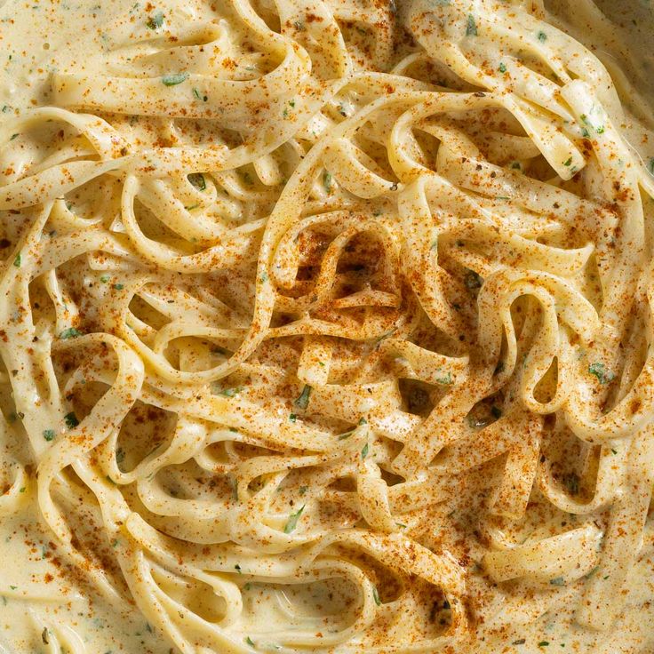 a bowl filled with pasta and sauce on top of a table