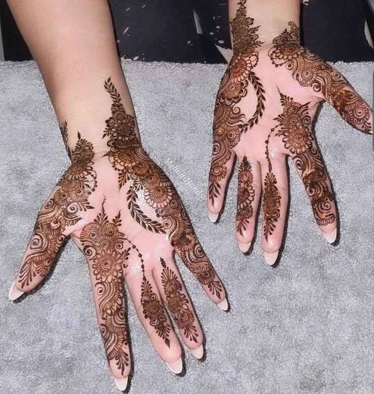 two hands with henna designs on them