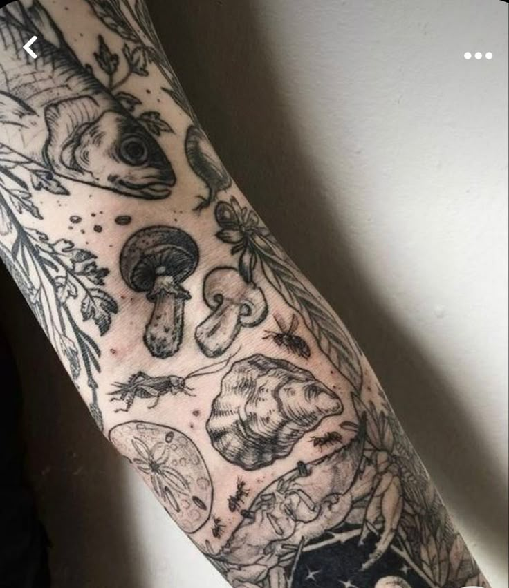 an arm with tattoos on it and various things in the background, such as mushrooms